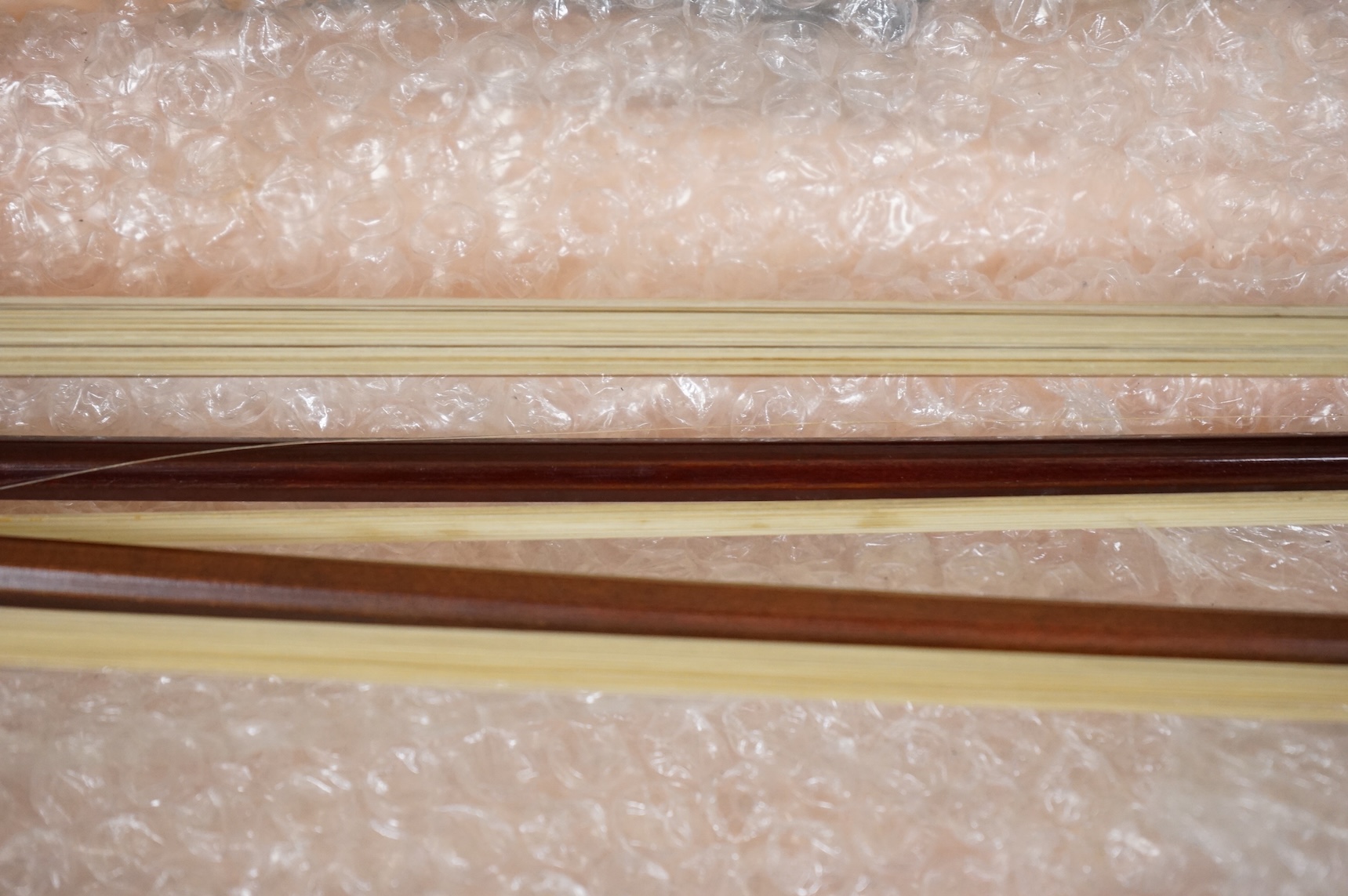 Three German violin bows; an octagonal stick stamped Penzal, together with another stamped E.L. Herrmann and a further unsigned example, all octagonal sticks and fully mounted with nickel mounts, together with an early 2